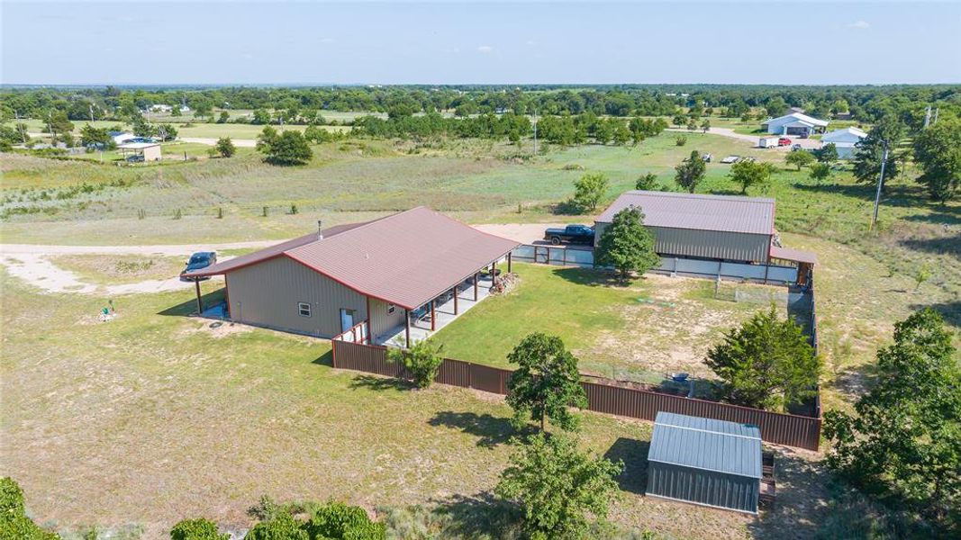 Property featuring a main residence with a metal roof and an additional detached building Property featuring a main residence with a metal roof and an additional detached building