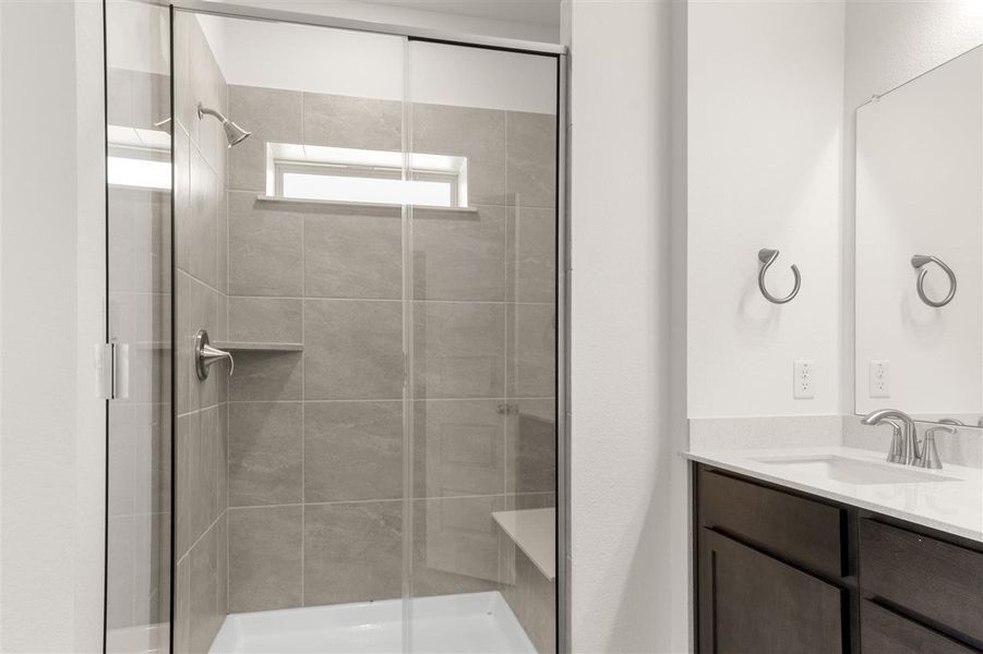 Bathroom featuring a stall shower and vanity