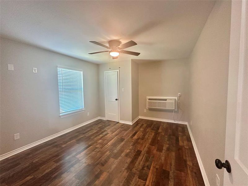 Upstairs Bedroom featuring a mini split wall unit, LVP flooring, and a ceiling fan Upstairs Bedroom featuring a mini split wall unit, LVP flooring, and a ceiling fan