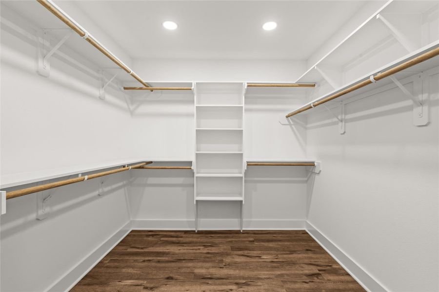 A wardrobe enthusiast's dream. The primary walk-in closet comes fully equipped with wrap-around custom built-ins, open shelving, and multi-level hanging rods.