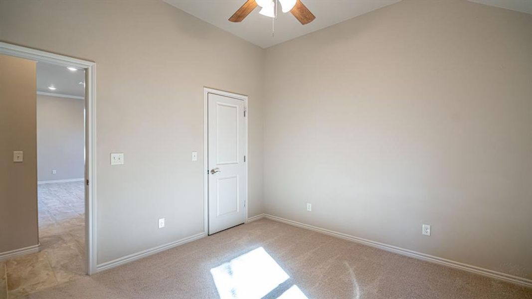 Unfurnished bedroom with light colored carpet and ceiling fan