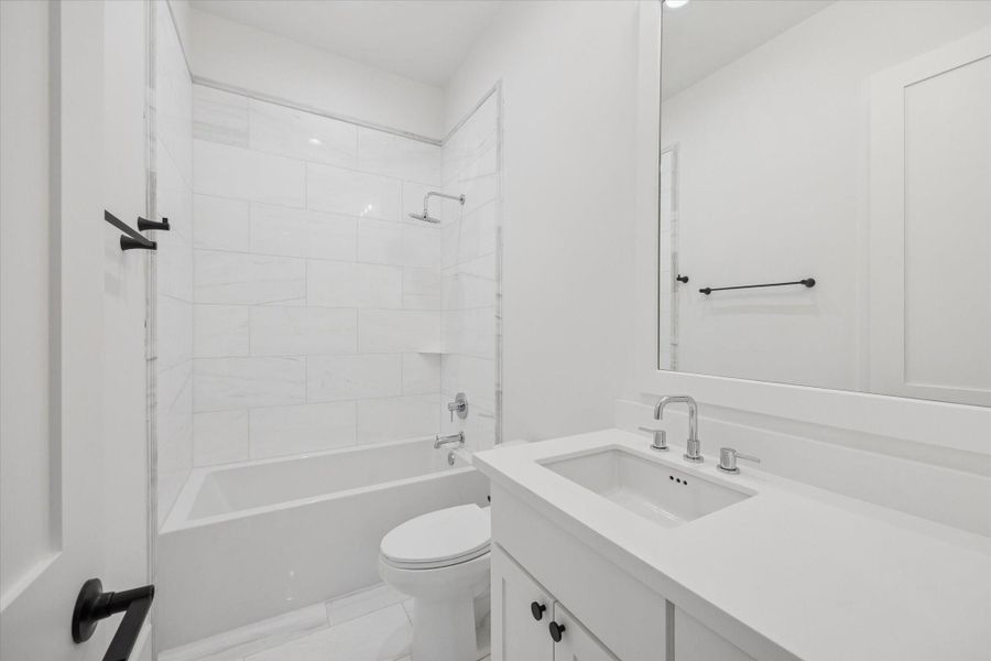 Clean tilework and a tub and shower combination make this secondary bath both practical and easy to maintain. A spacious vanity and neutral finishes allow the space to serve guests or daily use without sacrificing style or durability. Clean tilework and a tub and shower combination make this secondary bath both practical and easy to maintain. A spacious vanity and neutral finishes allow the space to serve guests or daily use without sacrificing style or durability.