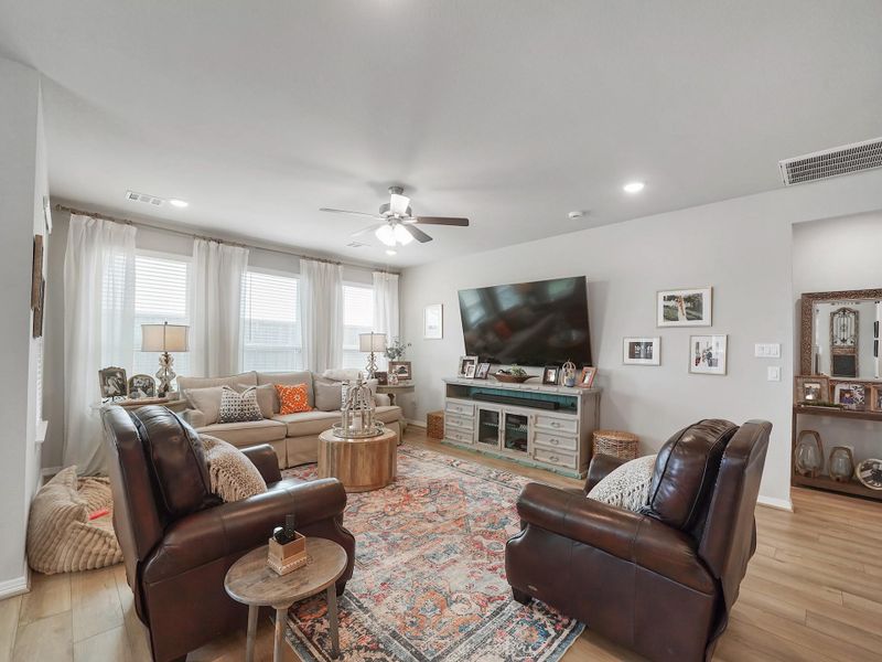 Large windows bring in natural light, enhancing the warmth of the space and creating a bright, welcoming atmosphere.