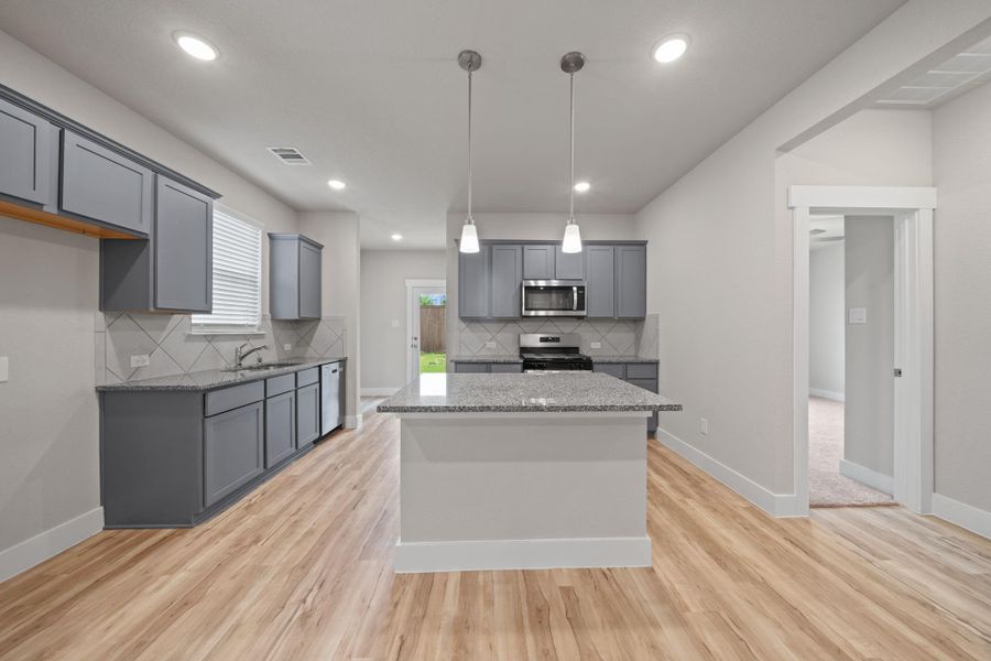 Step into a stunning modern kitchen designed for both style and function! This space features sleek granite countertops, custom grey cabinetry, and a spacious center island perfect for meal prep or casual dining.