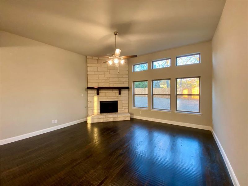 Wall of windows in Family room with stone to ceiling gas fireplace (stone is grey in this home to match interior)