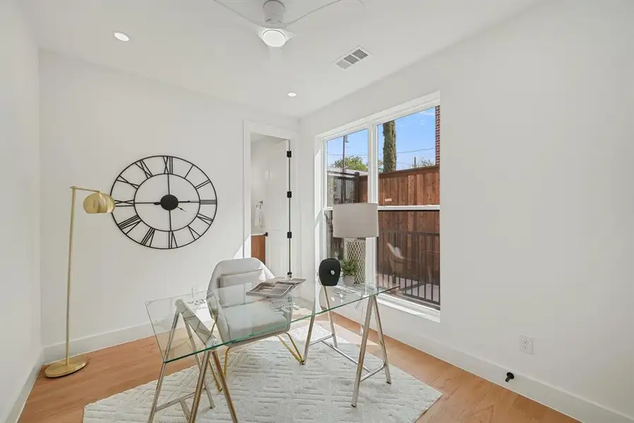 Bright room featuring light wood-finish flooring, white walls, a multi-pane window, and recessed lighting Bright room featuring light wood-finish flooring, white walls, a multi-pane window, and recessed lighting