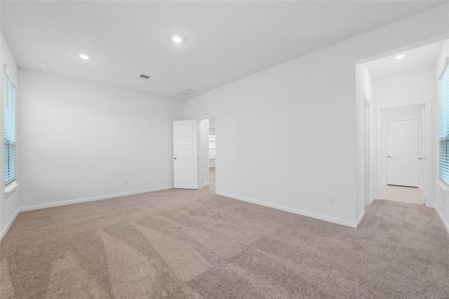 This view from the primary bedroom shows the seamless flow to the spacious walk-in closet and luxurious en-suite bathroom, creating a true suite experience.
