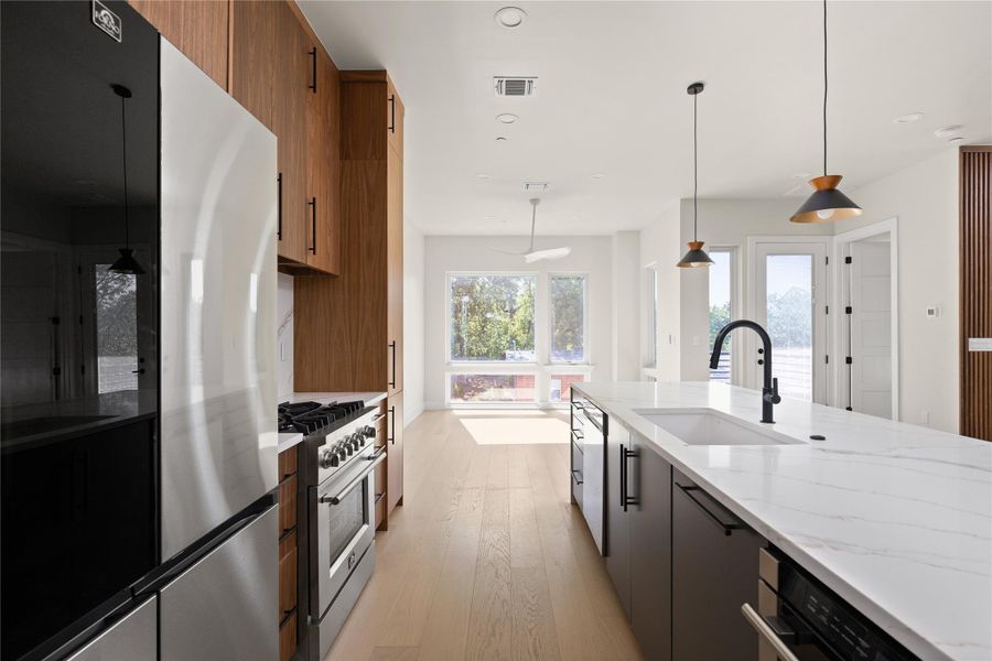 An open floorplan connects the modern kitchen directly to light-filled living spaces.