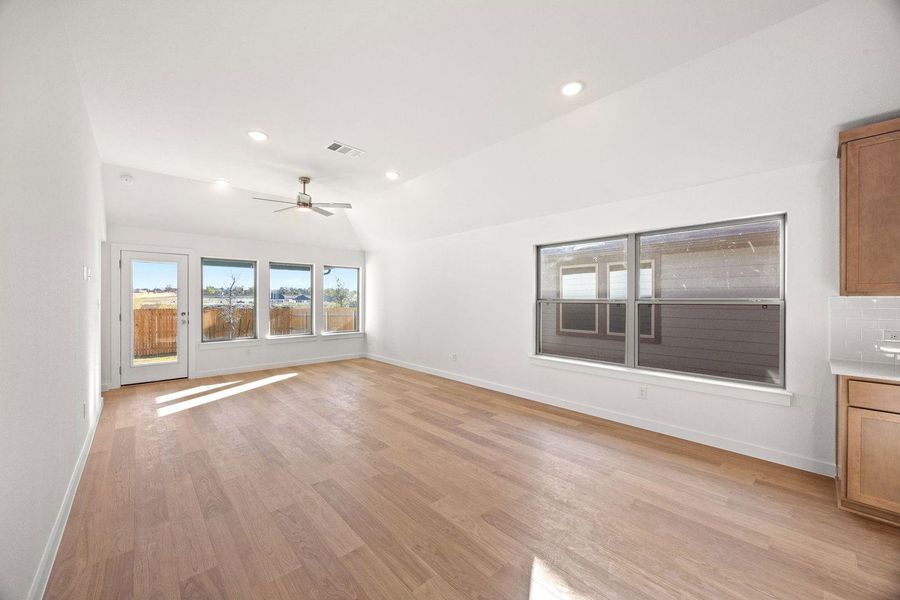 Sun-filled open-concept living area with gleaming hardwood flooring and direct outdoor access.