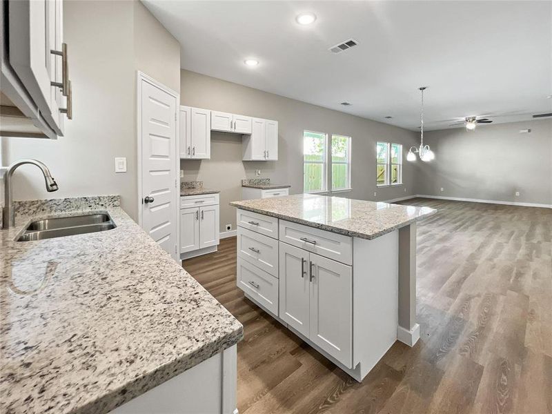 Kitchen featuring dark wood-style flooring, a center island, white cabinets, ceiling fan, and recessed lighting
