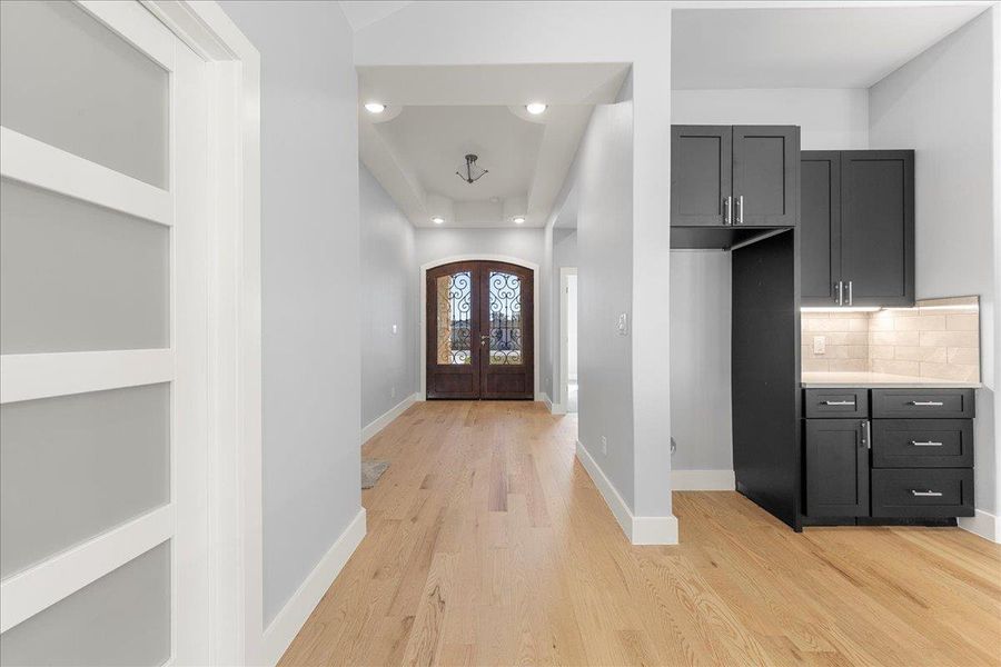 Foyer entrance featuring recessed lighting, light wood finished floors, french doors, and arched walkways Foyer entrance featuring recessed lighting, light wood finished floors, french doors, and arched walkways