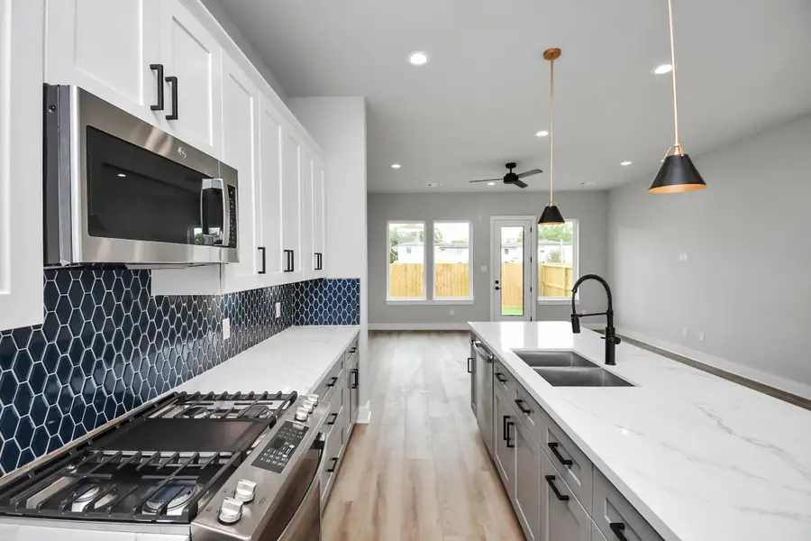 Beautiful kitchen with a large island, gas range, and eye-catching designer backsplash. Open layout with great natural light, ideal for entertaining.