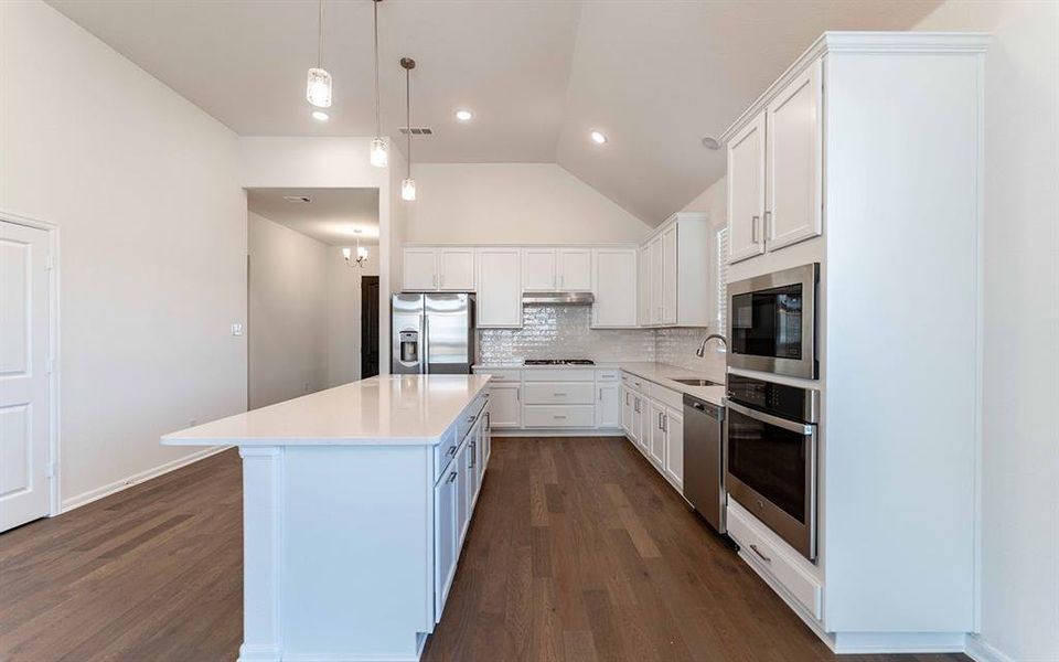 Kitchen featuring an expansive center island with a quartz countertop, recessed lighting, wood-finish flooring, white cabinetry, and stainless steel appliances