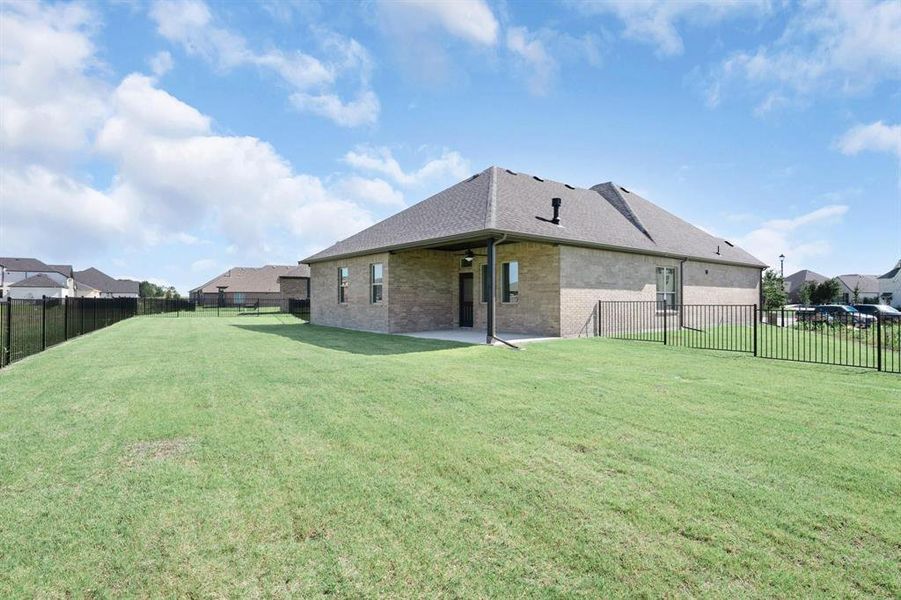 Backyard featuring a metal fence, a covered patio with a ceiling fan, and a residential view