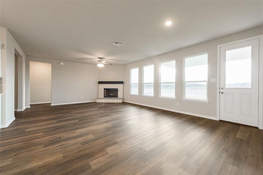 Unfurnished living room featuring dark wood-style floors, a fireplace, ceiling fan, and recessed lighting