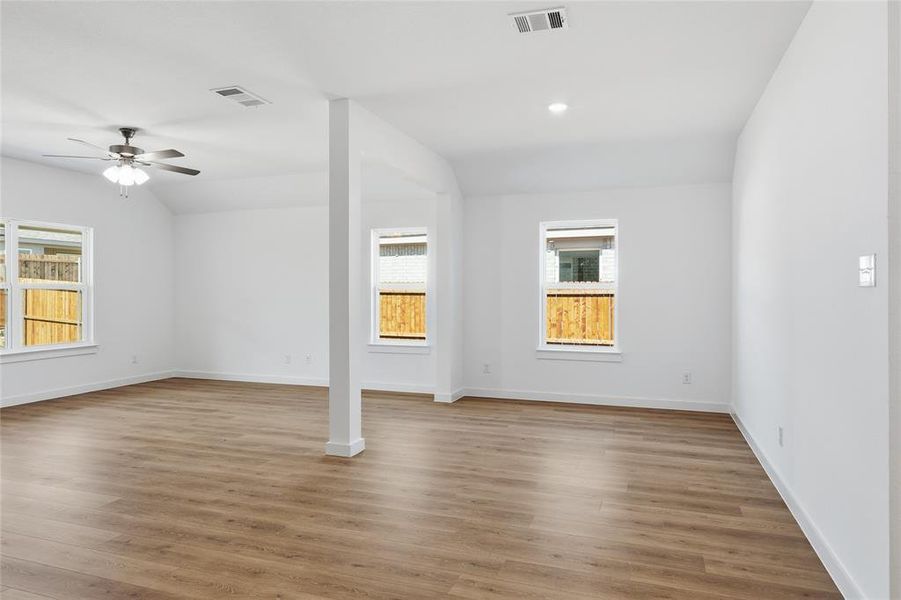 Spare room featuring ceiling fan, light wood-type flooring, and lofted ceiling