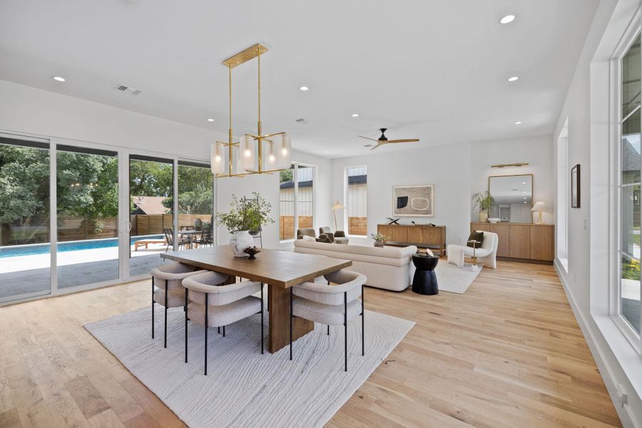 Dining space with recessed lighting, light wood-type flooring, plenty of natural light, ceiling fan, and a chandelier Dining space with recessed lighting, light wood-type flooring, plenty of natural light, ceiling fan, and a chandelier