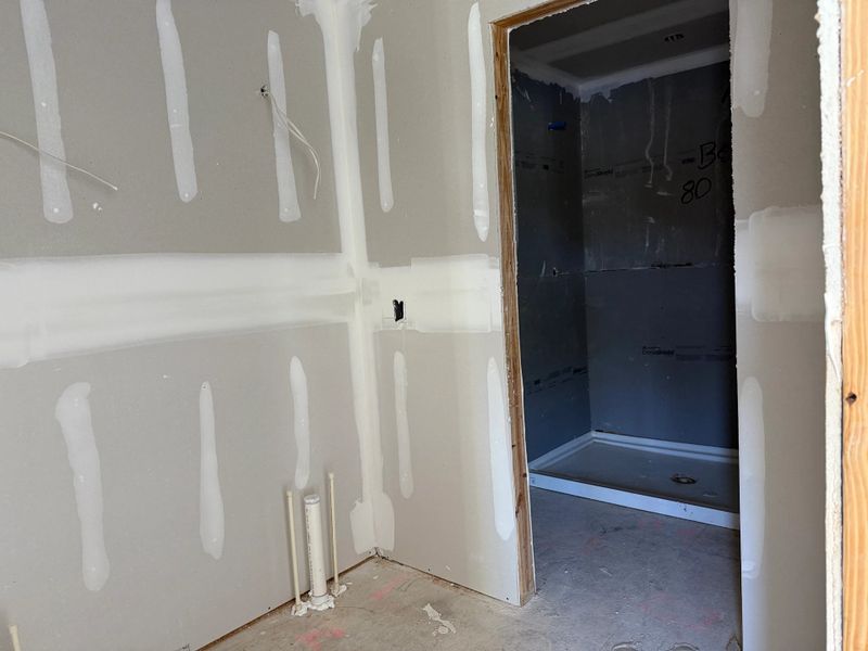 Luxurious primary bathroom features a spa-like glass shower