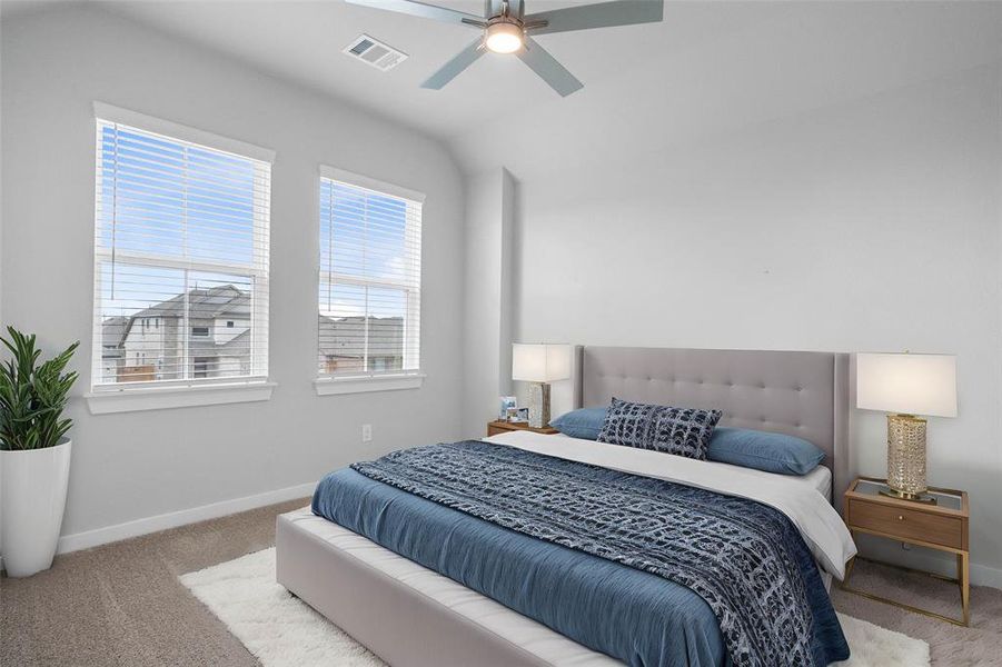 Secondary bedroom features plush carpet, custom paint, ceiling fan and large windows with privacy blinds.