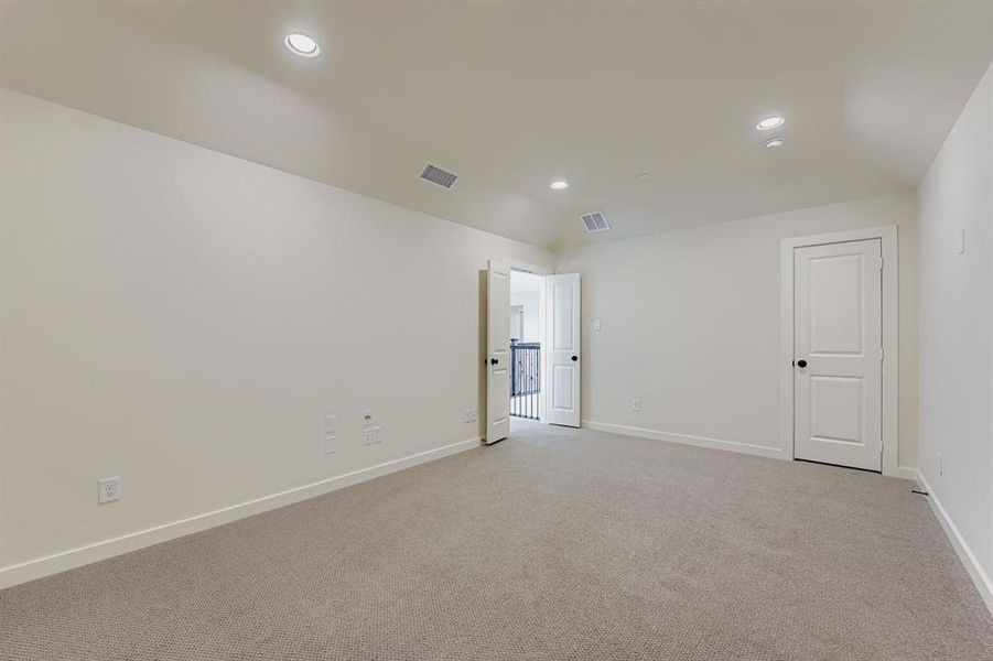Media room with light colored carpet and recessed lighting