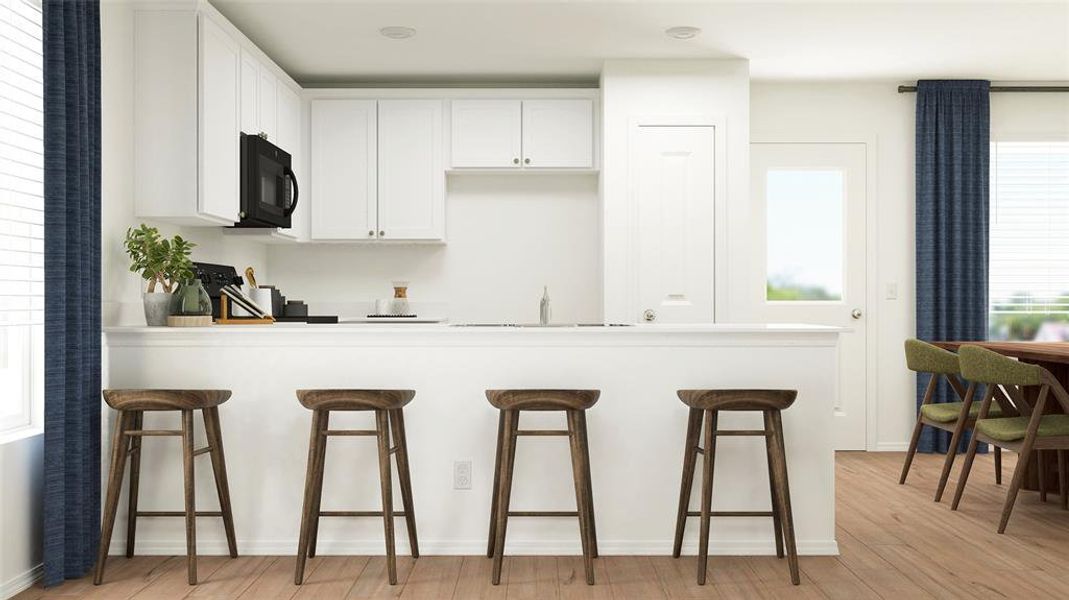 Kitchen with a kitchen breakfast bar, range, white cabinets, and light wood-type flooring