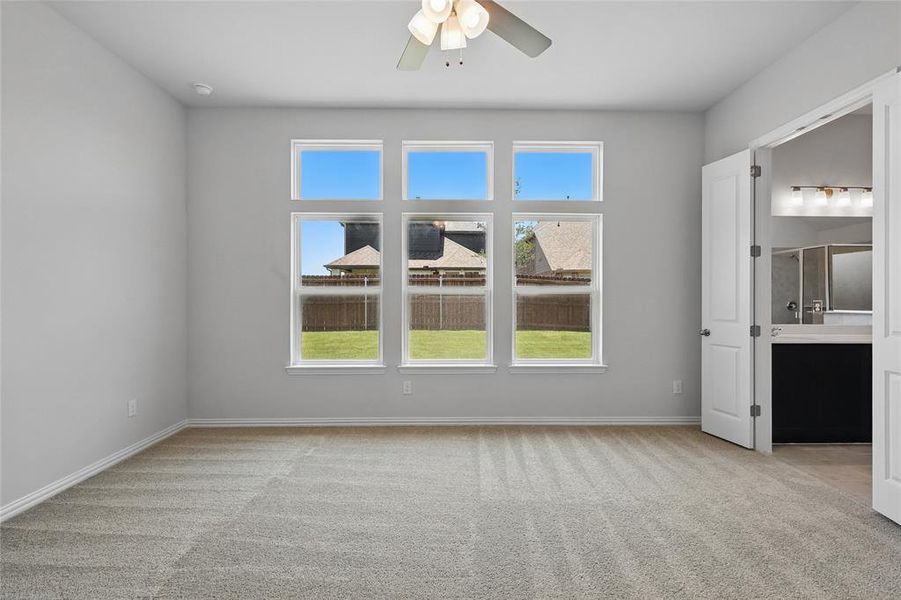 Unfurnished bedroom featuring carpet flooring, multiple windows, and baseboards