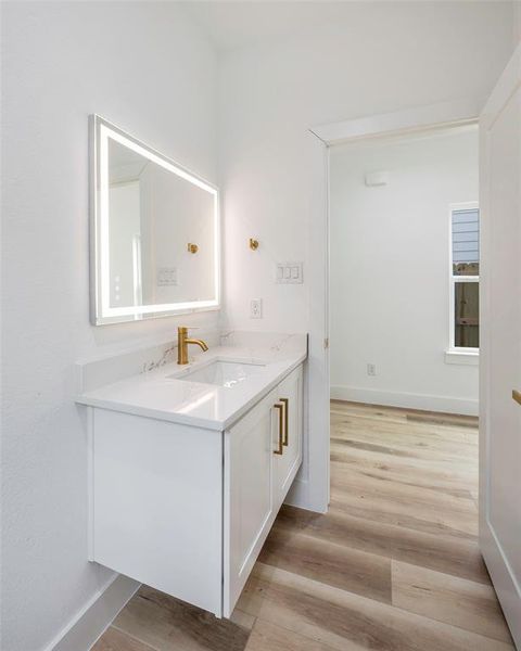 Kitchen with light stone counters, pendant lighting, and appliances with stainless steel finishes