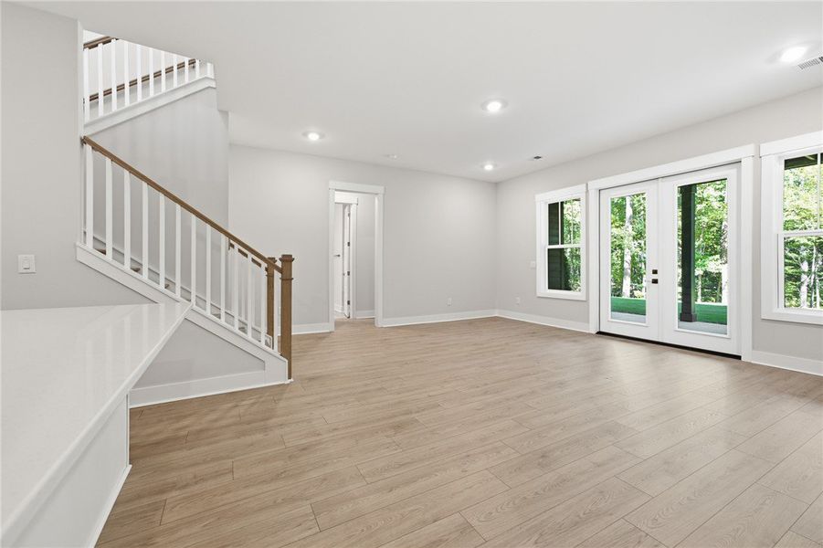 Gleaming wood floors and a custom staircase define