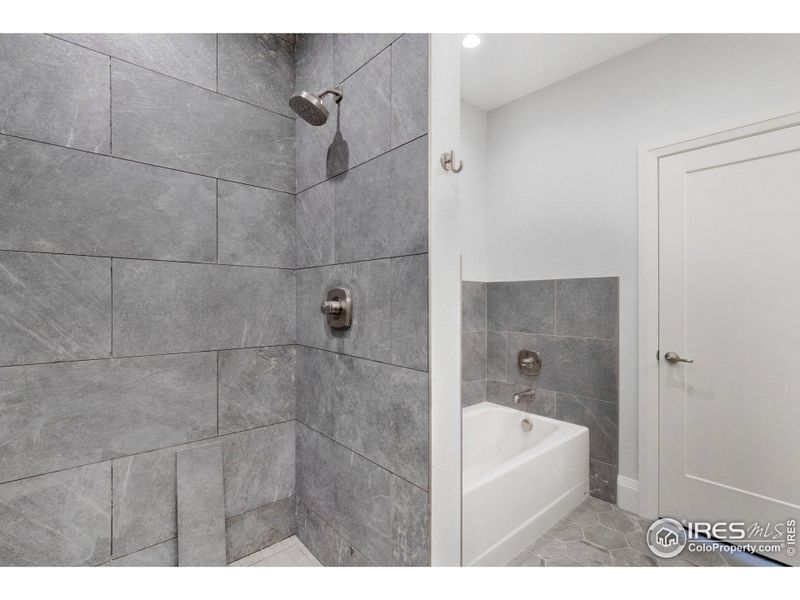 Floor-to-ceiling tile in the large shower, plus a real cast iron tub