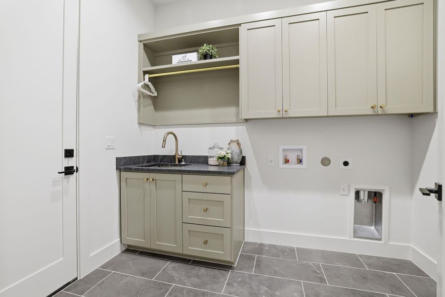 Laundry room with cabinet space, washer hookup, electric dryer hookup, gas dryer hookup, and dark tile patterned flooring