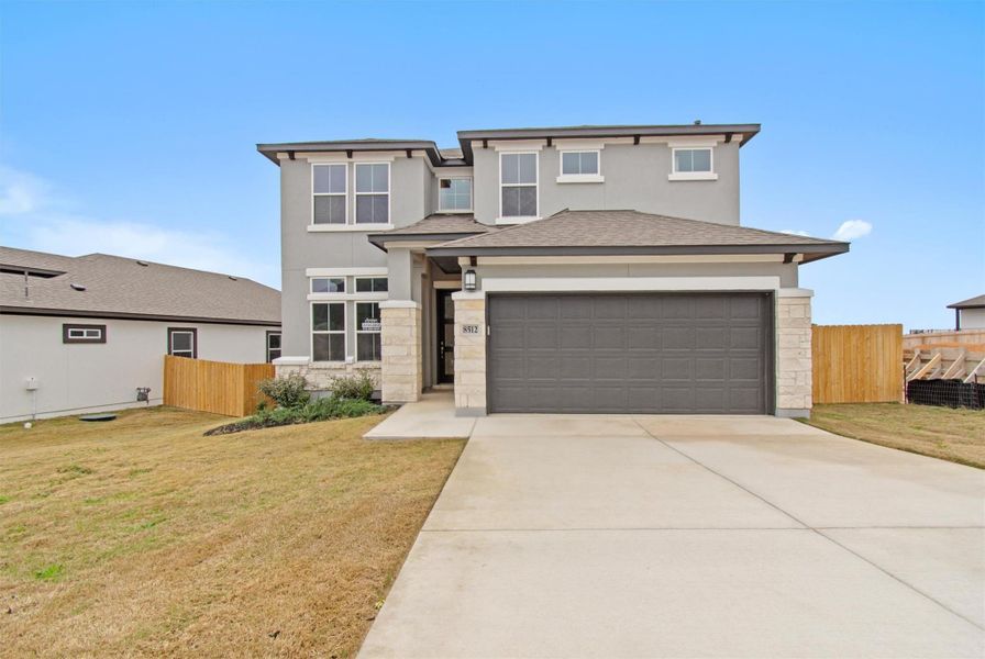 Prairie-style home with a garage and a front lawn