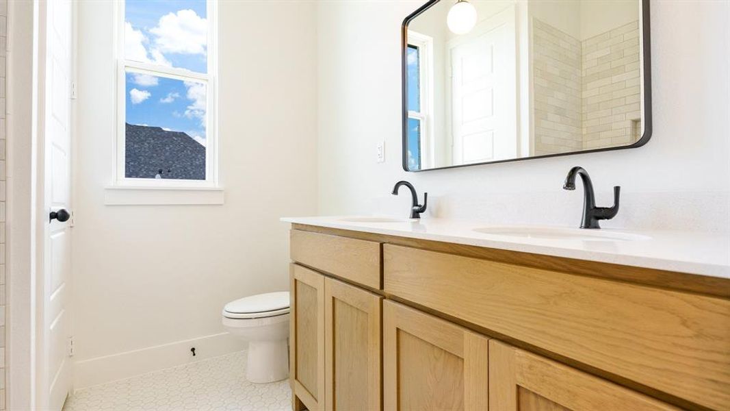 Bathroom with vanity, toilet, and tile patterned floors