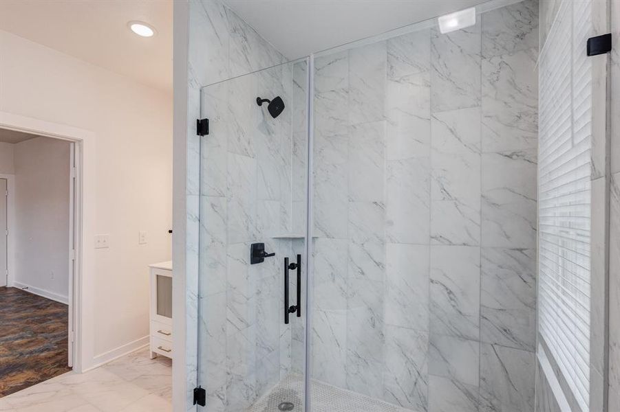 Bathroom with tile patterned floors, a shower with door, and vanity