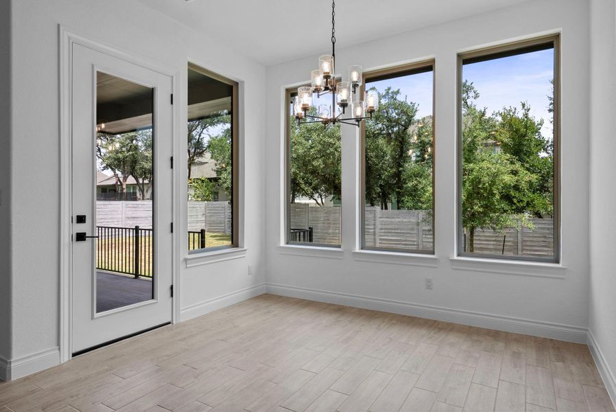 Light-filled breakfast area with large windows and direct access to the covered patio.