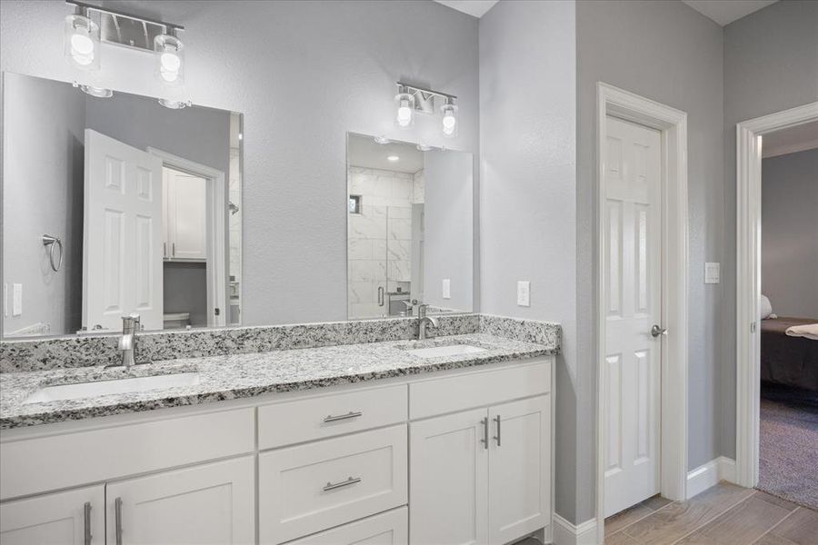 Primary bathroom featuring a shower with shower door and vanity