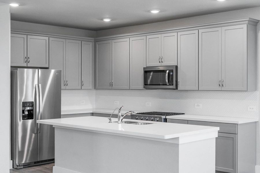 Discover this chef-ready kitchen featuring sleek, grey shaker-style cabinetry, pristine white quartz countertops, and a full suite of stainless steel appliances, including an over-the-range microwave and a side-by-side refrigerator. Discover this chef-ready kitchen featuring sleek, grey shaker-style cabinetry, pristine white quartz countertops, and a full suite of stainless steel appliances, including an over-the-range microwave and a side-by-side refrigerator.