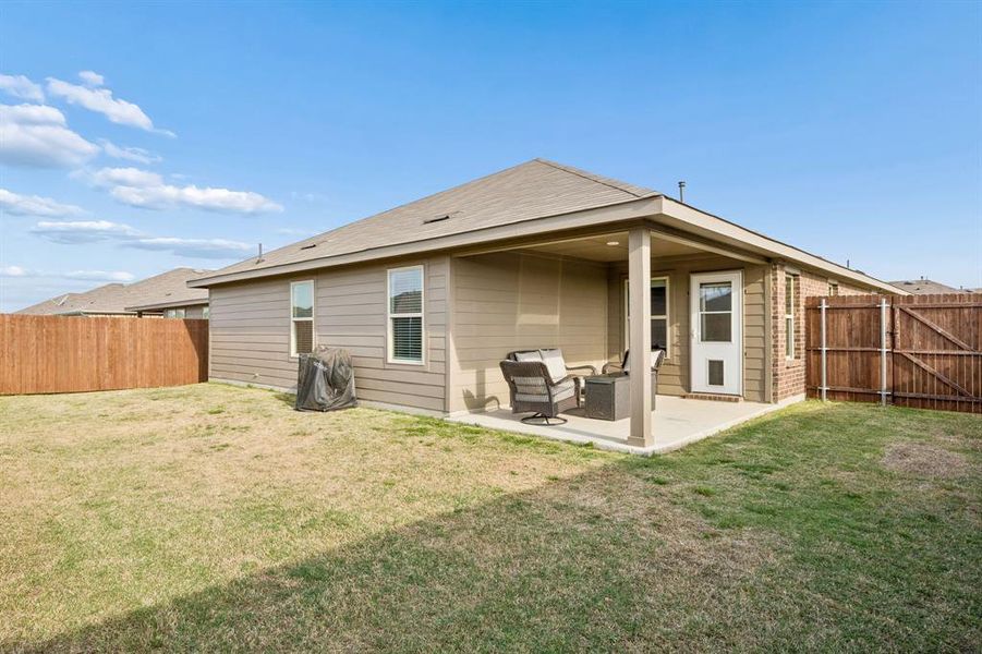 Back of house with a patio area, a fenced backyard, and a gate Back of house with a patio area, a fenced backyard, and a gate