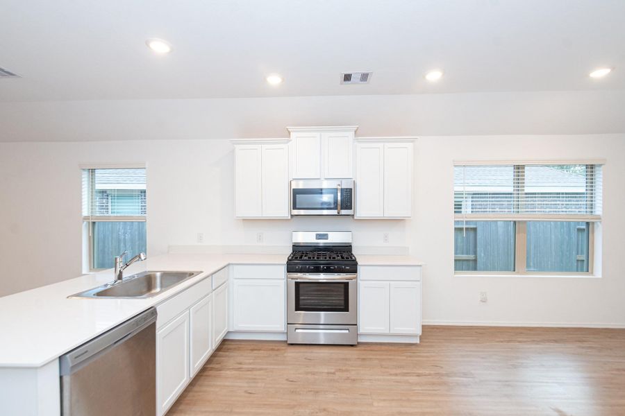 Modern stainless steel appliances enhance the kitchen's sleek and stylish appeal.