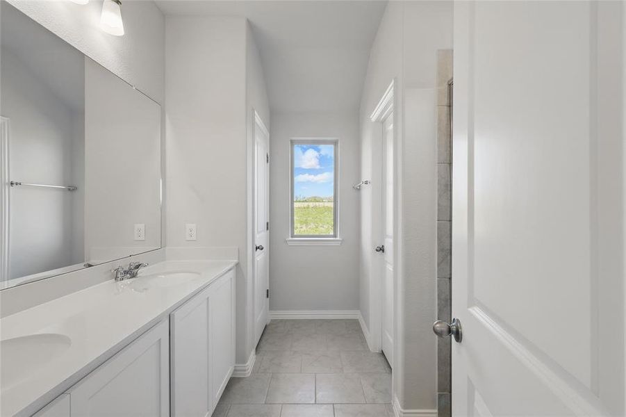 Bathroom featuring double vanity and tile patterned flooring Bathroom featuring double vanity and tile patterned flooring