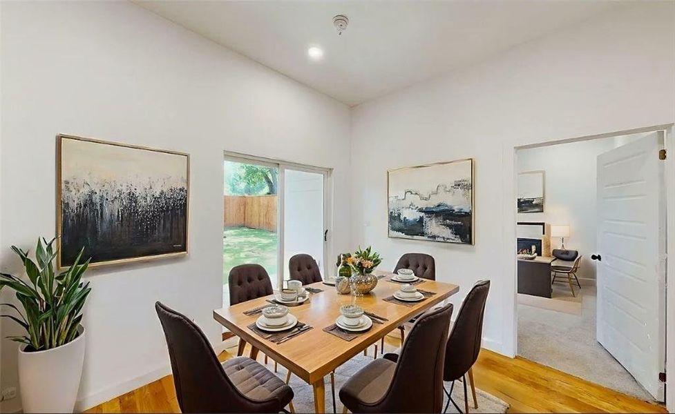 Dining space featuring wood-finish flooring, recessed lighting, and a sliding glass door to the backyard