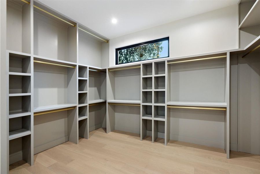 Large primary closet with plenty of space for hanging and storage along with natural light.