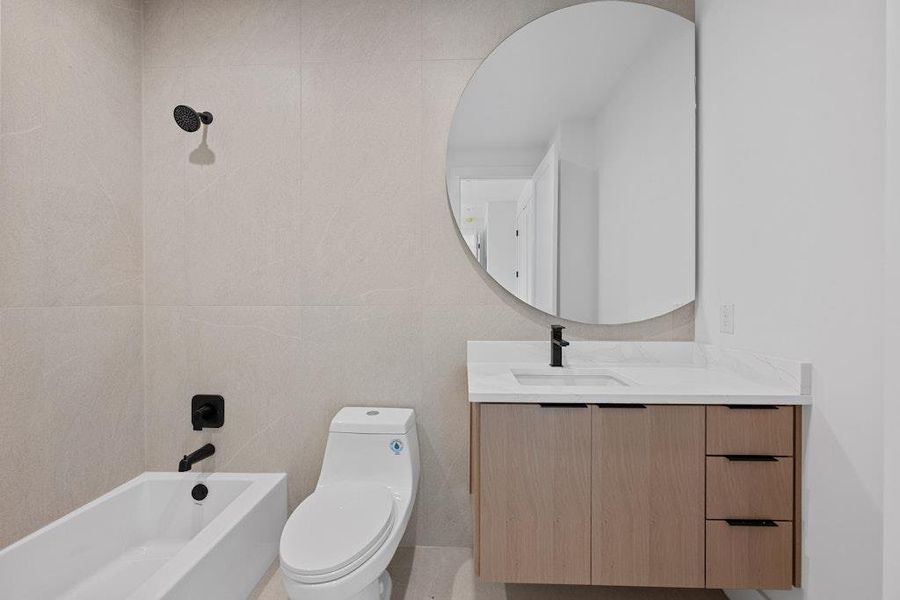Full bathroom with vanity, shower / bath combination, and tile walls