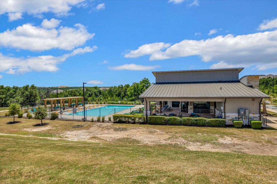An inviting outdoor pool with a covered patio area beckons for relaxation and recreation under clear skies. An inviting outdoor pool with a covered patio area beckons for relaxation and recreation under clear skies.