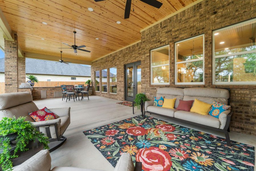 Expansive covered patio featuring a wood-finish tongue and groove ceiling, recessed lighting, and multiple ceiling fans