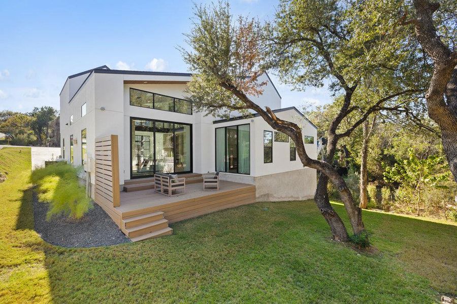 The deck is surrounded by a serene setting, perfect for al fresco dining, summer barbecues, or simply enjoying the Hill Country breeze.