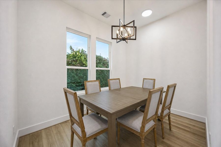 Just beyond the kitchen, the dining area comfortably accommodates seating for eight, making it ideal for both everyday meals and entertaining. Just beyond the kitchen, the dining area comfortably accommodates seating for eight, making it ideal for both everyday meals and entertaining.