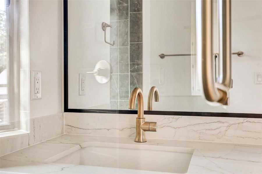 Bathroom featuring a sink and tasteful backsplash