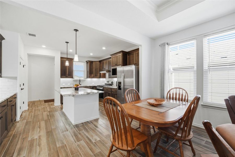 Dining space with wood finish floors, recessed lighting, and ornamental molding