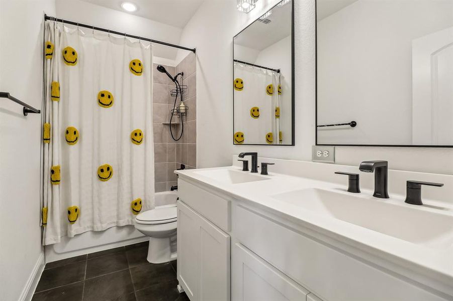 Full bathroom with shower / bath combo with shower curtain, toilet, tile patterned flooring, and a sink Full bathroom with shower / bath combo with shower curtain, toilet, tile patterned flooring, and a sink