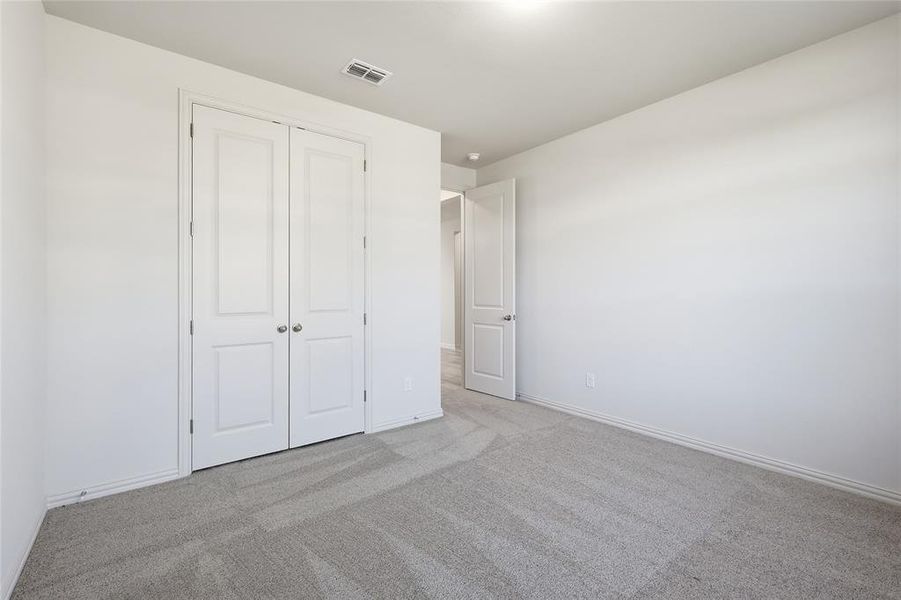 Unfurnished bedroom featuring light colored carpet and a closet Unfurnished bedroom featuring light colored carpet and a closet